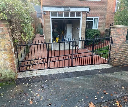 Bi folding metal gate with a sloping bottom rail