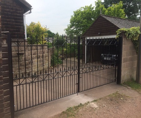Wrought iron style double metal gates securing a driveway entrance
