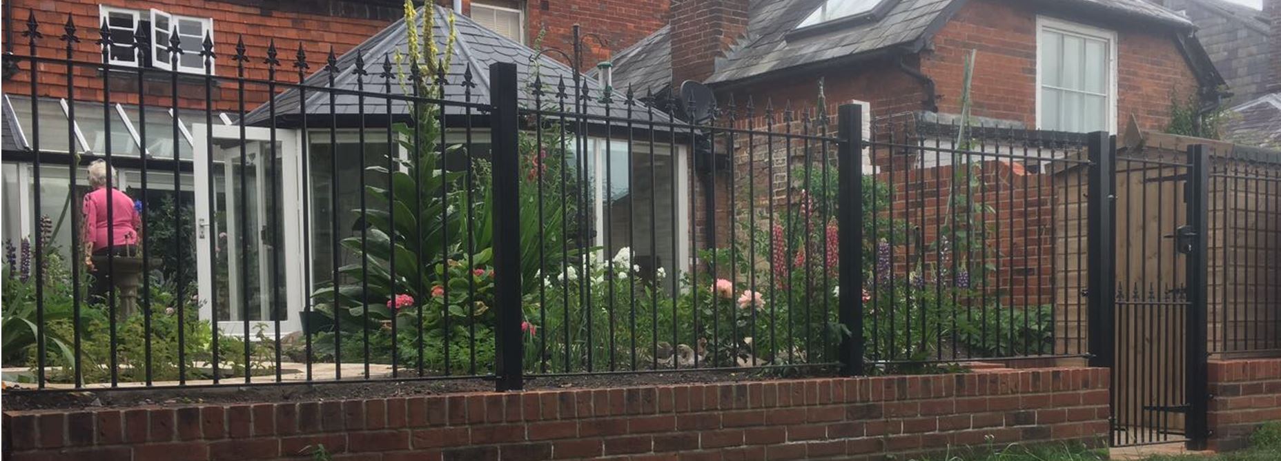 Saxon iron railings and bolt down posts on back garden wall