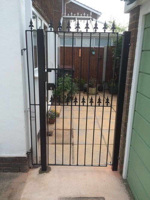 Spear top metal gate mounted to metal posts