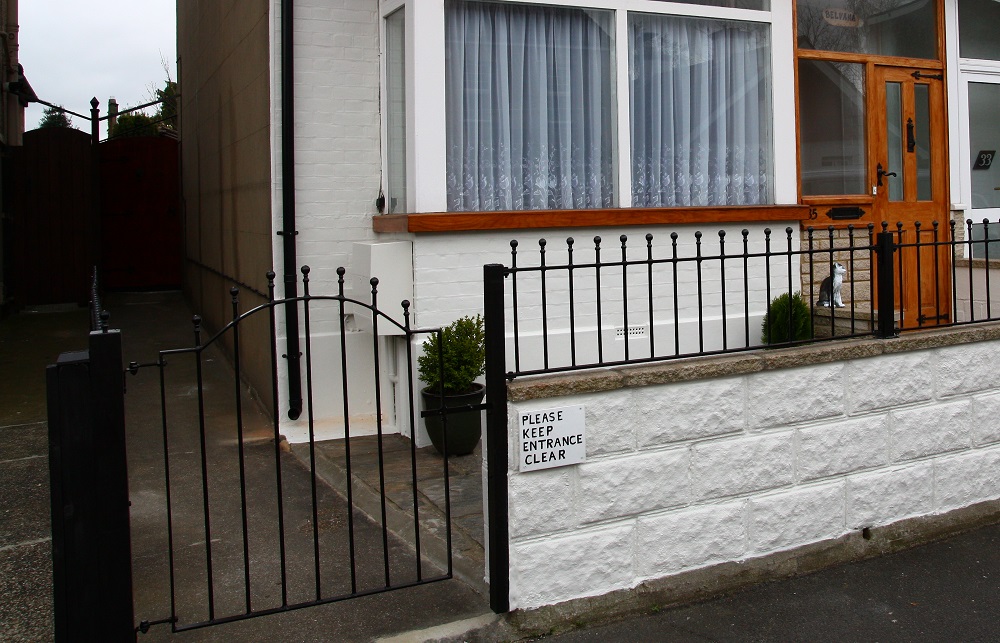 Metal garden gate and railings adding security to the front entrance of a residential property