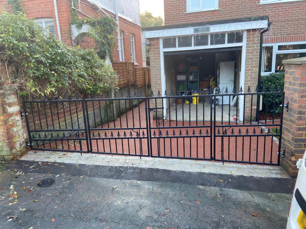 Wrought iron gate with a sloping bottom rail