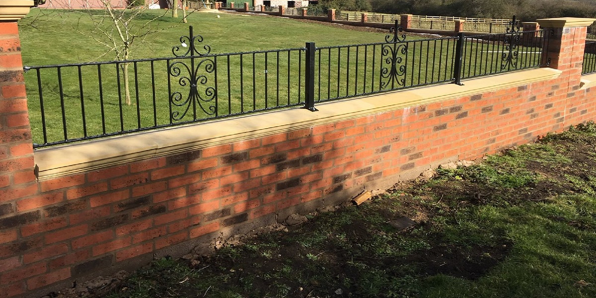 Ornate wrought iron railings within brick wall